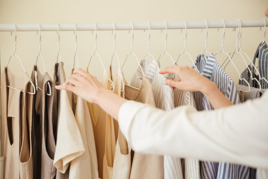 A women maintain her wardrobe by the hand and arrange the cloth also.