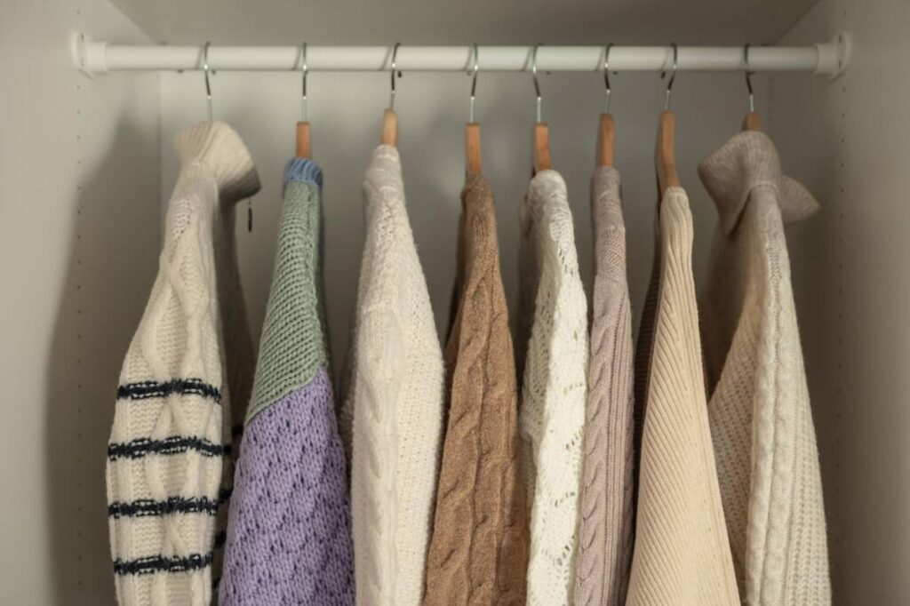 Capsule wardrobe with neatly arranged neutral and statement colour clothing.