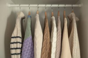 Capsule wardrobe with neatly arranged neutral and statement colour clothing.